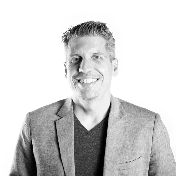 A black and white photo featuring a smiling man, curated by marketing experts.