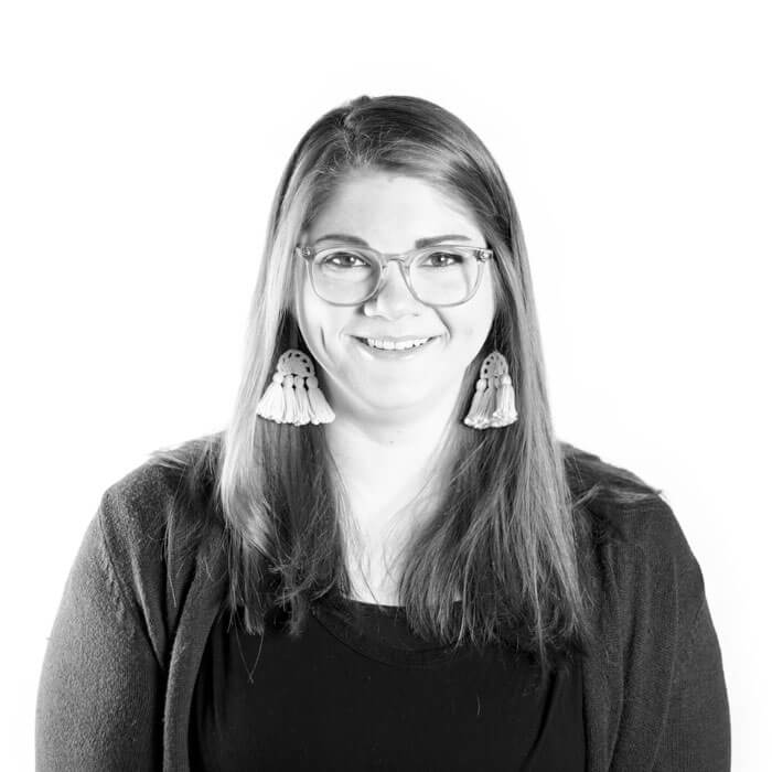 A black and white photo featuring a woman, wearing glasses, captured by marketing experts.