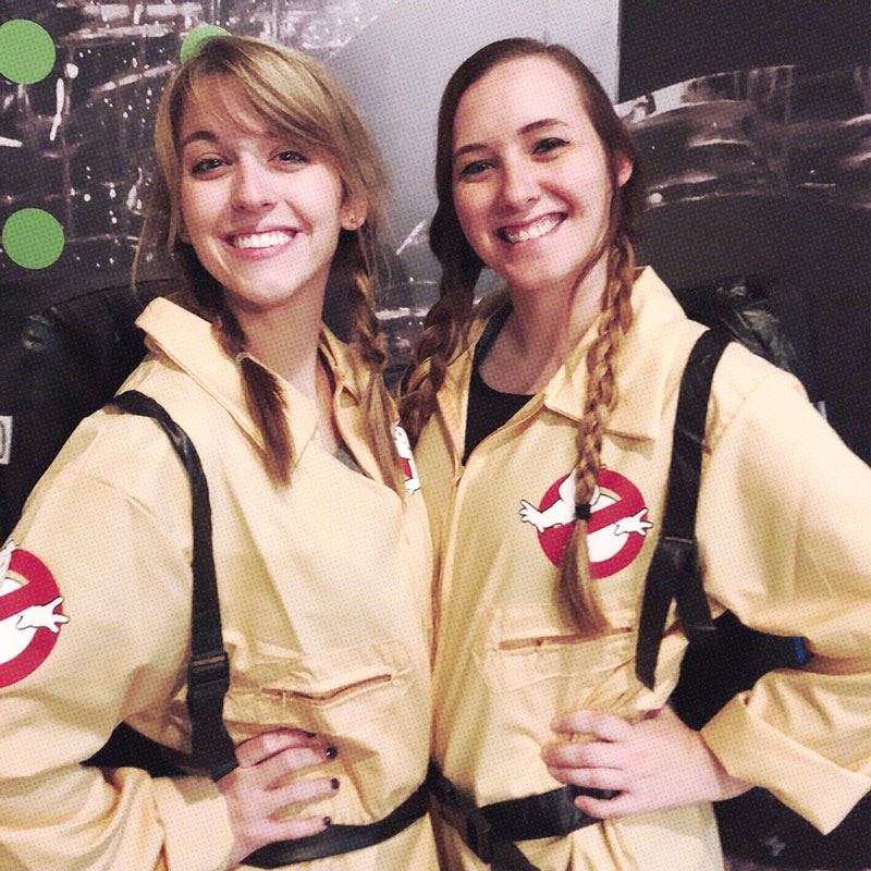 Two ardent women dressed as ghostbusters posing for a creative picture.