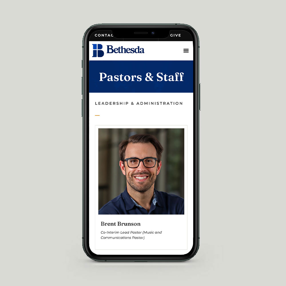 A smartphone displays the Bethesda Community Church website's "Pastors & Staff" page featuring Brent Brunson, Co-Interim Lead Pastor (Music and Communications Pastor), under the "Leadership & Administration" section.