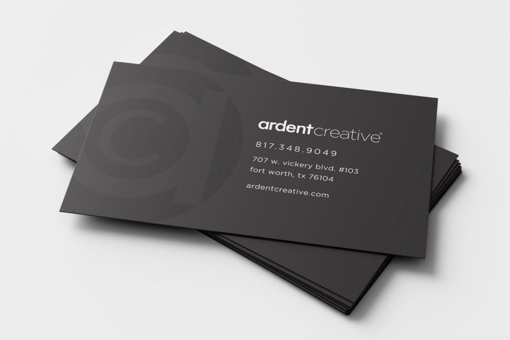 A stack of black business cards for ardent creative, printed with contact info, address, and website in white text on a minimalist design.
